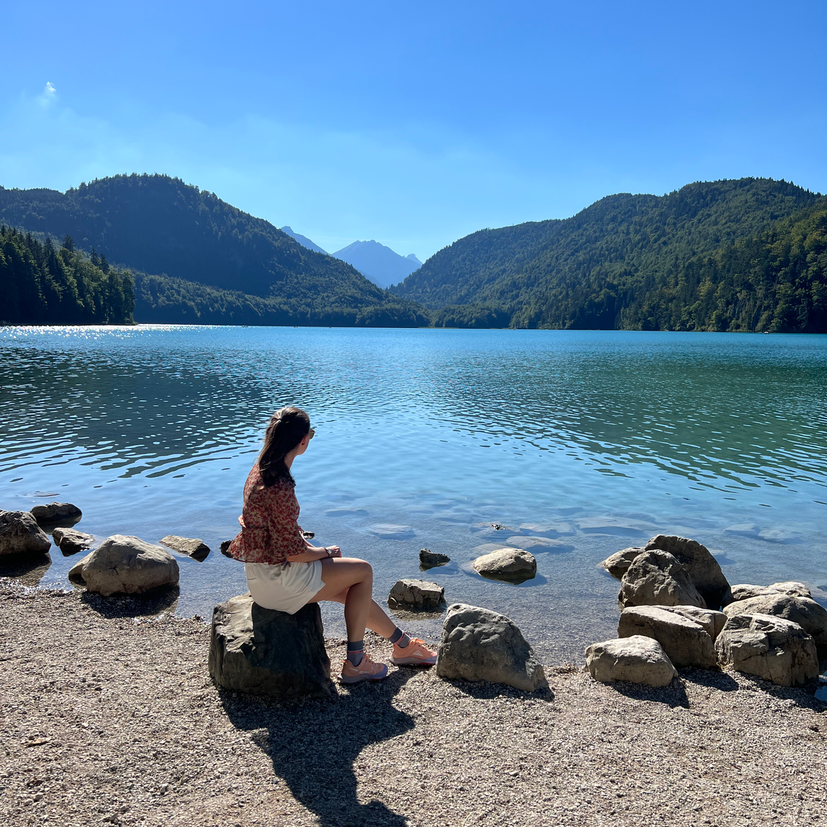 48 HOURS IN HOHENSCHWANGAU Woman sitting at Lake Alpsee
