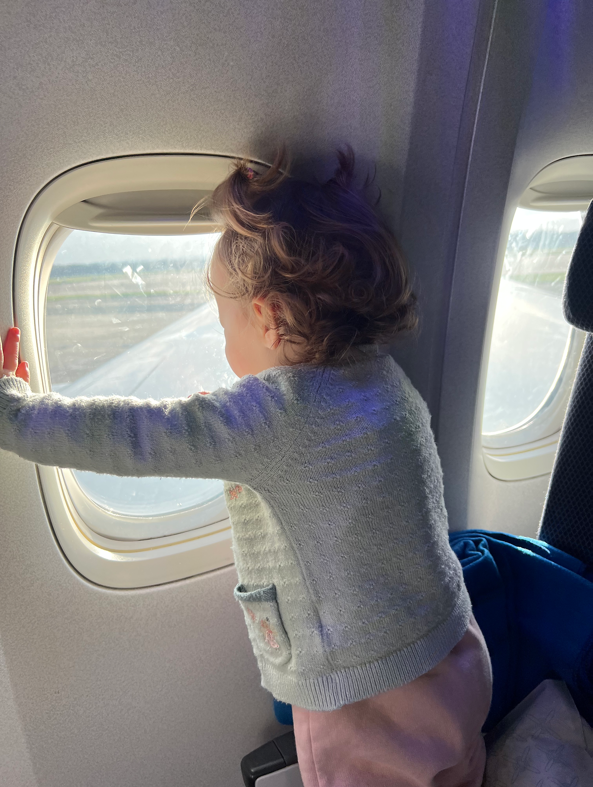 TIPS FOR FLYING LONG HAUL WITH A TODDLER baby on aeroplane looking out window