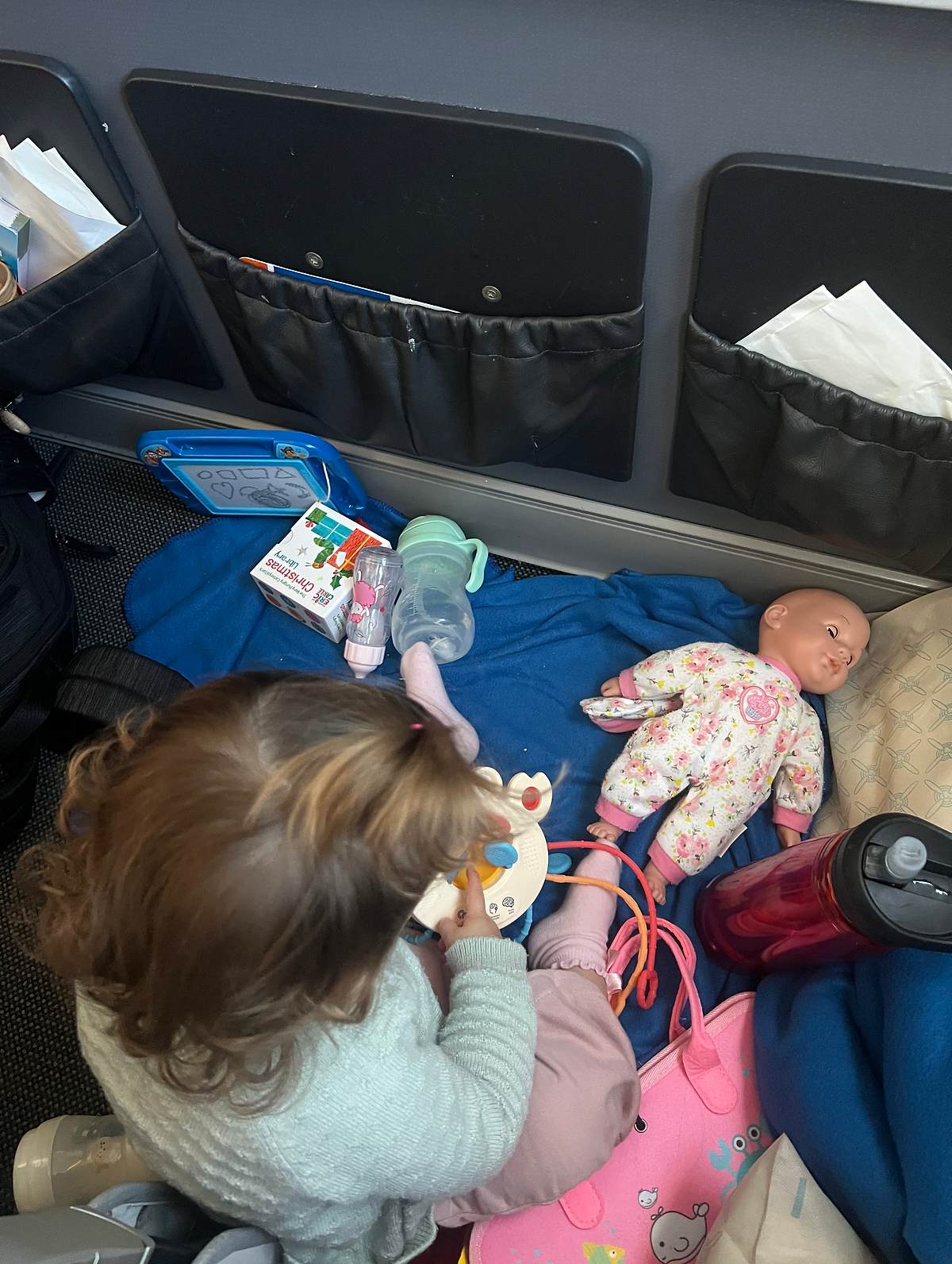 TIPS FOR FLYING LONG HAUL WITH A TODDLER baby playing with toys